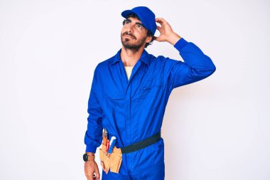 Kıvırcık saçlı ve ayı gibi giyinen yakışıklı genç adam soru sormayı merak ediyor. Şüpheyle kararsız, kafa kafaya düşünerek. Düşünceli kavram. 