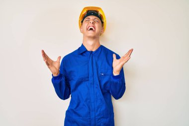 İşçi üniforması giyen ve başarı için çıldıran şapkalı genç İspanyol çocuk kollarını kaldırmış ve gözlerini kapatmış heyecanla haykırıyor. Kazanan konsept 