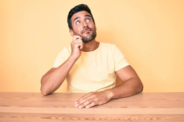 Young Hispanic Man Wearing Casual Clothes Sitting Table Serious Face — Stock Photo, Image