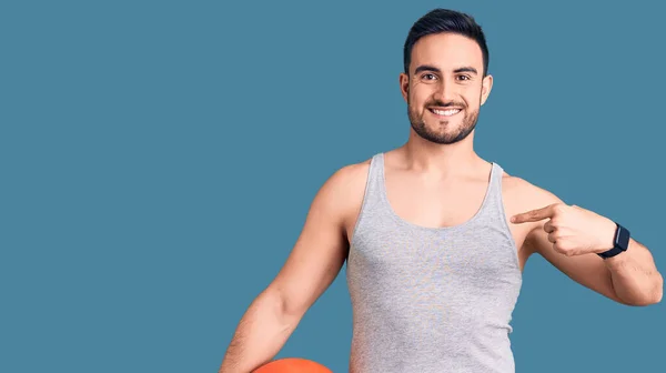 Junger Gutaussehender Mann Hält Basketballball Und Zeigt Mit Dem Finger — Stockfoto