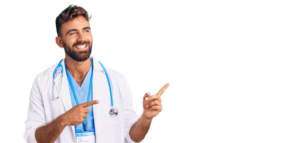 Młody Hiszpan Mundurze Lekarza Stetoskopie Uśmiechający Się Patrzący Kamerę Dwiema — Zdjęcie stockowe
