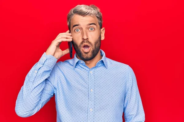 Joven Guapo Rubio Con Barba Conversando Hablando Smartphone Asustado Sorprendido —  Fotos de Stock