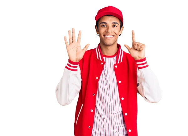 自信と幸せな笑顔ながら 若いアフリカ系アメリカ人の男は 野球の制服を着て指の番号7で示すと指摘します — ストック写真