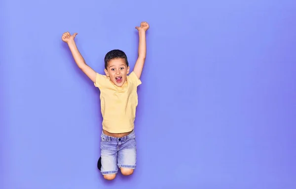 Adorable Niño Con Ropa Casual Saltando Sobre Fondo Púrpura Aislado — Foto de Stock