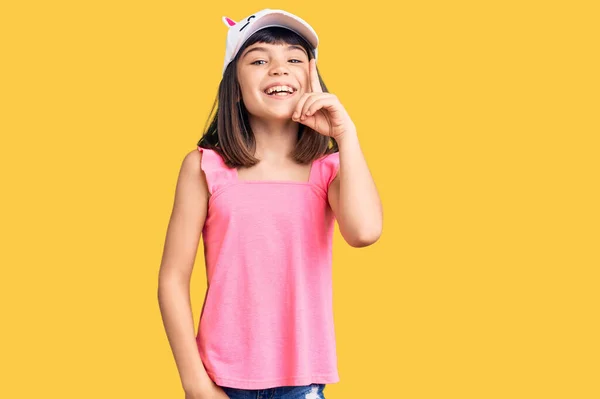 Młoda Dziewczynka Hukiem Nosząca Śmieszną Czapkę Wskazującą Palcem Udany Pomysł — Zdjęcie stockowe