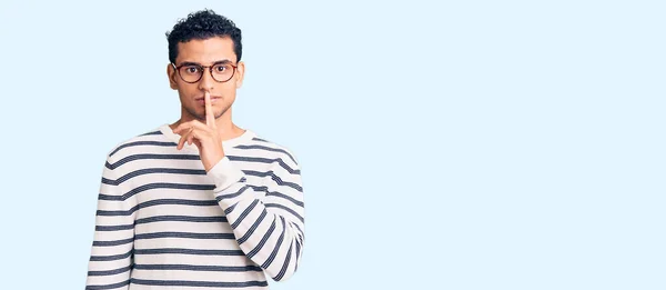 身穿休闲装戴眼镜的西班牙裔英俊年轻人要求安静 手指放在嘴唇上 沉默和秘密概念 — 图库照片
