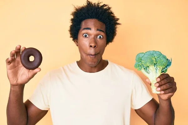 Hezký Africký Američan Afro Vlasy Drží Brokolici Čokoládové Koblihy Takže — Stock fotografie