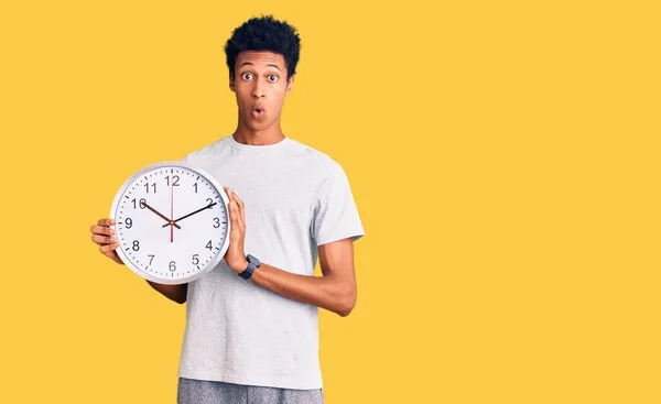 Jovem Afro Americano Segurando Grande Relógio Assustado Surpreso Com Boca — Fotografia de Stock