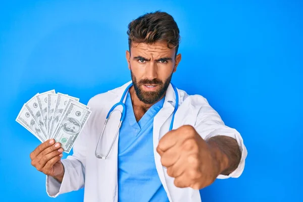 Ung Latinamerikan Man Bär Doktor Uniform Hålla Dollar Irriterad Och — Stockfoto