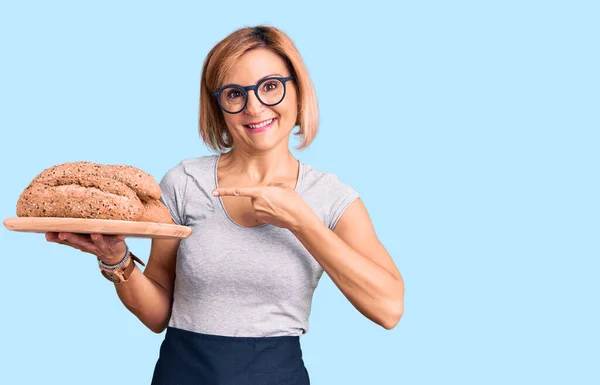 Jonge Blonde Vrouw Met Volkorenbrood Glimlachend Gelukkig Wijzend Met Hand — Stockfoto