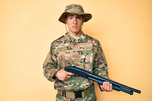 Jovem Homem Bonito Vestindo Uniforme Exército Camuflagem Segurando Espingarda Cético — Fotografia de Stock