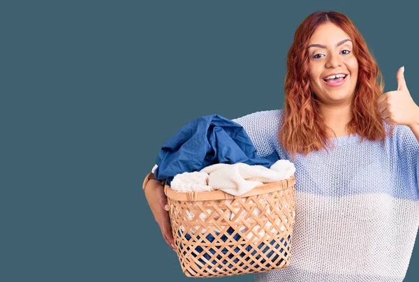 Young Latin Woman Holding Laundry Basket Smiling Happy Positive Thumb — Stock Photo, Image