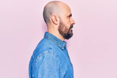 Sıradan kıyafetler giyen genç yakışıklı bir adam, rahat bir görünüm takınıyor kendine güvenen bir gülümsemeyle doğal bir yüz ifadesi takınıyor.. 