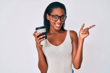 Genç Afrikalı Amerikalı kadın kahveyi alıp götürüyor. Gülümsüyor, mutlu bir şekilde işaret ediyor. 