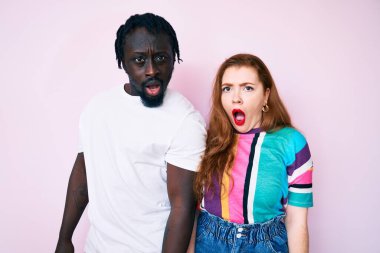 Şok olmuş gibi giyinen ırklar arası bir çift şüpheci ve alaycı görünüyor, ağzı açık kalınca şaşırıyorlar. 