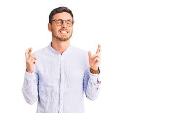 Zarif iş gömleği ve gözlük takan yakışıklı genç adam umut ve gözler kapalı gülümseyerek el sallıyor. Şans ve batıl inançlar. 