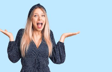 Genç ve güzel sarışın kadın, gündelik kıyafetler giyip çılgınlığı kutluyor ve başarıya hayret ediyor. Kolları açık, gözleri açık, heyecanlı bir şekilde bağırıyor. Kazanan konsept 