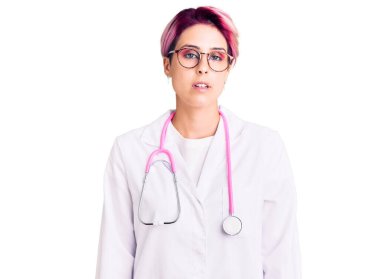 Pembe saçlı, doktor üniforması giyen, yüzünde ciddi bir ifade olan genç ve güzel bir kadın. Basit ve doğal bir şekilde kameraya bakıyorsun.. 