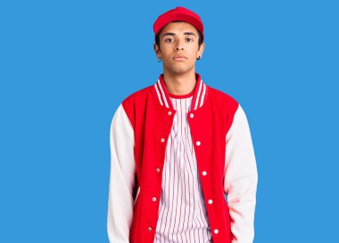 Beyzbol üniforması giyen genç Afrikalı Amerikalı adam yüzünde ciddi bir ifadeyle rahatladı. Basit ve doğal bir şekilde kameraya bakıyorsun.. 