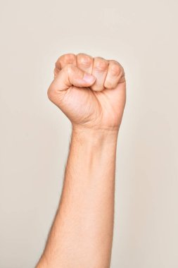 Beyaz arka planda protesto ve devrim hareketi yapan, güç ve güç gösterisi yapan beyaz tenli bir gencin eli.