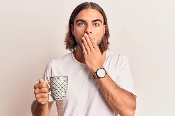 Ung Stilig Man Håller Kaffe Täcker Munnen Med Handen Chockad — Stockfoto