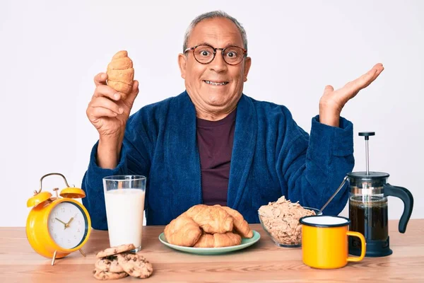 Homem Bonito Sênior Com Cabelos Grisalhos Sentado Mesa Comendo Croissant — Fotografia de Stock