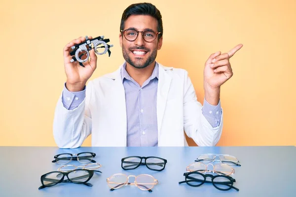 Joven Hombre Hispano Sosteniendo Gafas Óptica Sonriendo Feliz Señalando Con — Foto de Stock