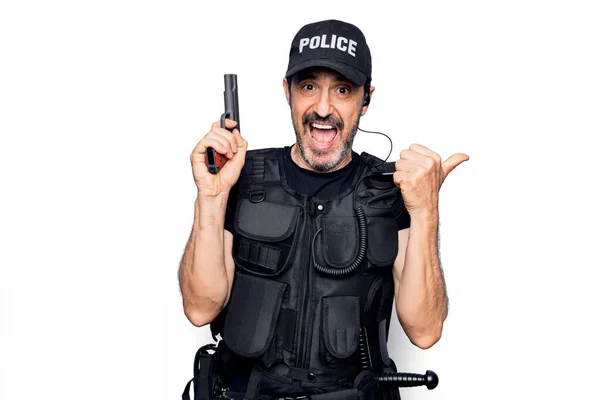 中年英俊警察身穿警服 身穿防弹背心 手持枪托着大拇指冲向侧边 高兴地张开嘴 — 图库照片