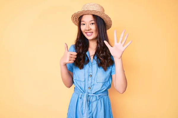 年轻美丽的中国姑娘头戴夏帽 头戴六号手指 面带微笑 自信而快乐 — 图库照片