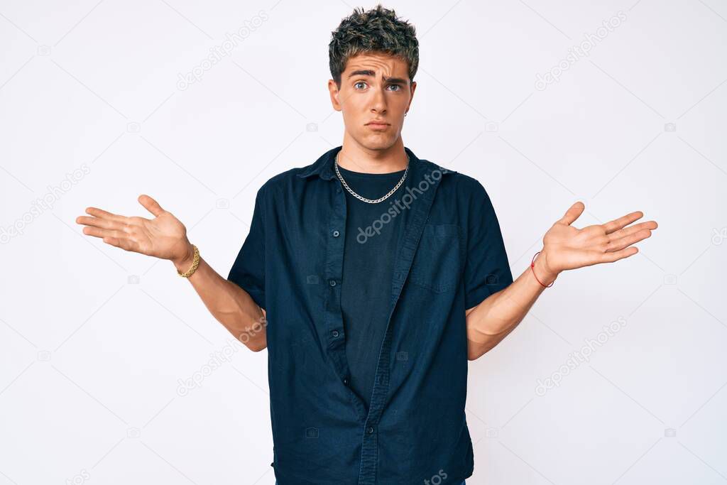 Young handsome man wearing casual clothes clueless and confused with open arms, no idea and doubtful face. 