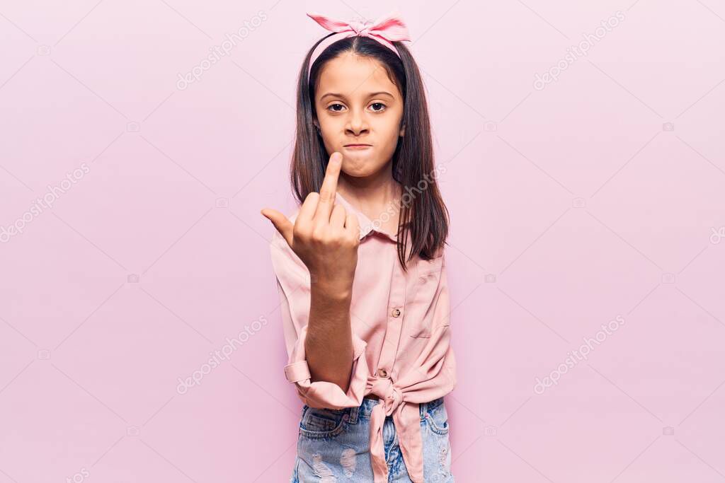 Beautiful child girl wearing casual clothes showing middle finger, impolite and rude fuck off expression 