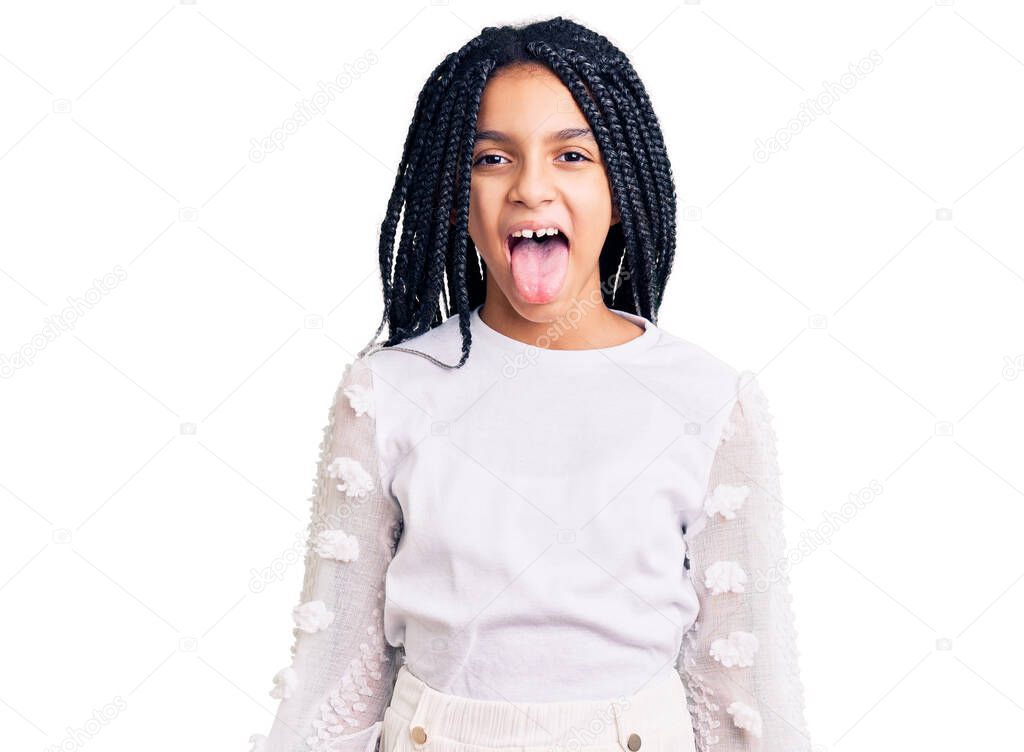 Cute african american girl wearing casual white tshirt sticking tongue out happy with funny expression. emotion concept. 
