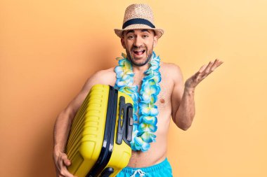 Mayolu yakışıklı ve kel bir adam ve ellerinde kamara çantasıyla zaferi mutlu bir gülümsemeyle kutluyorlar. 