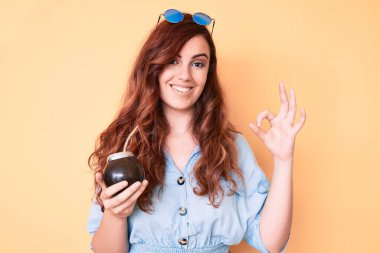 Genç ve güzel bir kadın içki arkadaşı aşıladı. Parmaklarınla imzala, gülümse, dostça işaretler yap. Mükemmel bir sembol. 