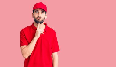 Sakallı yakışıklı bir adam teslimat üniforması giyiyordu. Düşüncelerinde şüphe vardı. Parmakları çenesinde ve yukarı bakıyordu. 