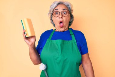 İspanyol asıllı yaşlı, gri saçlı, önlüklü kadın. Yara temizleyicisini tutuyor. Şaşırmak için ağzı açık kalmış, imansız bir yüz. 