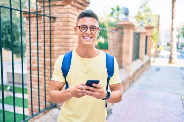 Joven Estudiante Hispano Sonriendo Feliz Usando Smartphone Caminando Por Calle —  Fotos de Stock