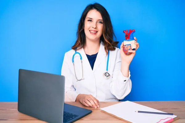 Young Beautiful Brunette Woman Wearing Doctor Uniform Holding Heart Looking — Stock Photo, Image