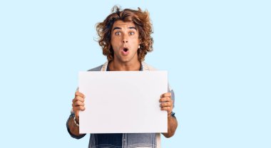 Genç İspanyol adam boş pankart tutuyor. Korkmuş ve ağzı açık kalmış, şaşırmış ve şaşırmış. 