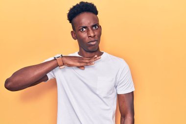 Genç Afro-Amerikalı sıradan kıyafetler giymiş, boğazını bıçak niyetine kesen, saldırganlığı şiddetle tehdit eden bir adam. 