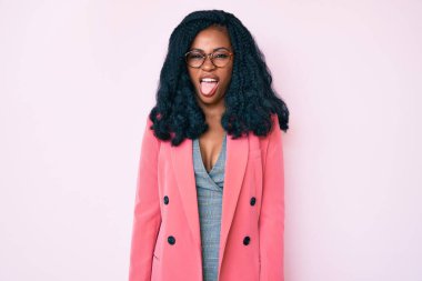 İş ceketi ve gözlük takan güzel Afrikalı kadın komik bir ifadeyle dilini dışarı çıkartıyor. duygu kavramı. 