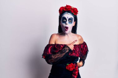 Ölü makyajlı genç bir kadın parmaklarını kenarı göstererek şaşırdı ve ağzı açık kaldı.. 