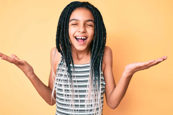 黄色の背景に翼を持つ若いアフリカ系アメリカ人の少女の子供は 腕を上げて興奮して叫んで目を閉じて成功のために狂気と狂気を祝う 勝者のコンセプト — ストック写真