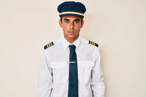 Young Hispanic Man Wearing Airplane Pilot Uniform Relaxed Serious Expression — Stock Photo, Image