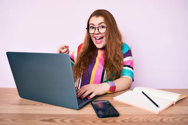 Ofiste Çalışan Genç Kızıl Saçlı Kadın Dizüstü Bilgisayarla Gülümsüyor — Stok fotoğraf