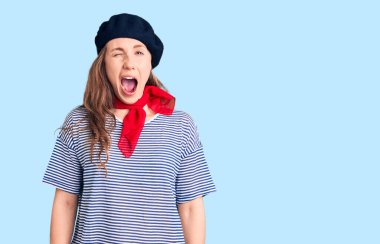 Fransız beresi ve çizgili tişört giyen genç, güzel sarışın kadın kameraya seksi bir ifadeyle bakıyor, neşeli ve mutlu bir yüzle.. 