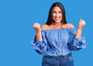 Genç, güzel, esmer bir kadın gündelik tişört giyip gururla bağırıyor, zaferi kutluyor ve kollarını kaldırarak çok heyecanlanıyor. 