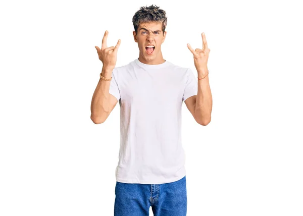 Fiatal Jóképű Férfi Alkalmi Fehér Pólóban Őrült Arckifejezéssel Rock Szimbólumot — Stock Fotó
