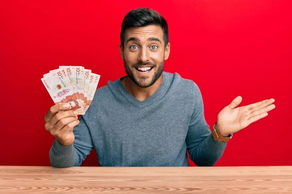 Hombre Hispano Guapo Sosteniendo Pesos Colombianos Celebrando Logro Con Sonrisa —  Fotos de Stock