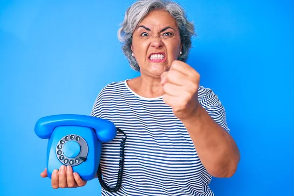 Starsza Latynoska Siwa Kobieta Trzymająca Starodawny Telefon Zirytowana Sfrustrowana Krzykiem — Zdjęcie stockowe